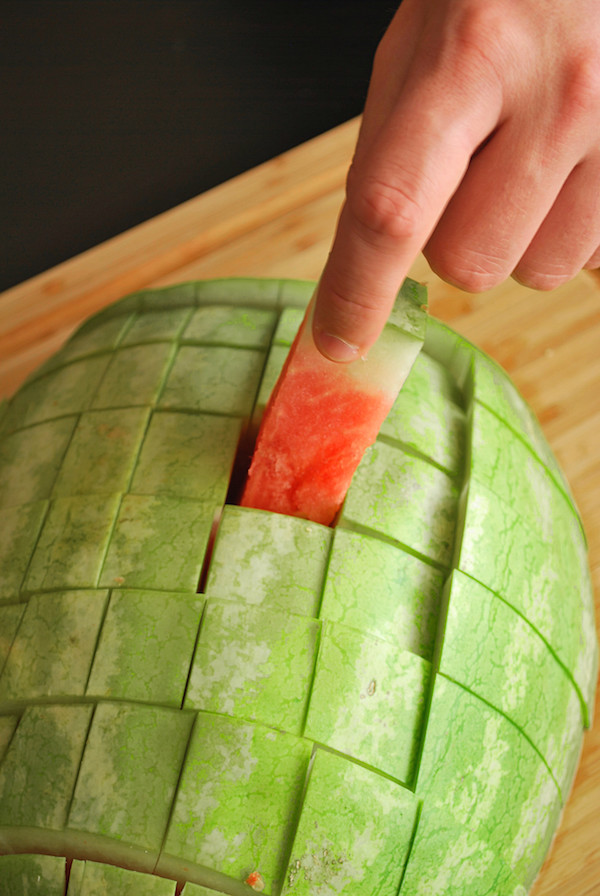 watermelon cut into a grid on a cutting board