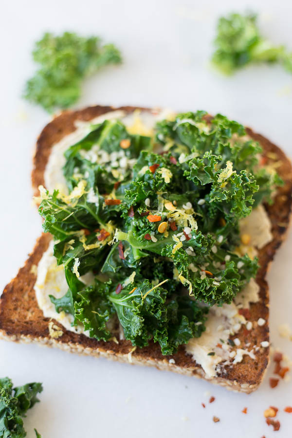 Hummus Kale Toast: a delicious gluten free and vegan breakfast or snack! Flavors like garlic, lemon, and red pepper flakes make for a truly spectacular toast! || fooduzzi.com recipes