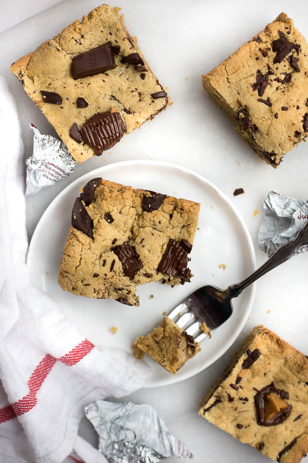 Vegan Peanut Butter Cup Blondies: Dense and chewy blondies are filled with peanut butter cups and dark chocolate! Naturally gluten free, vegan, and refined sugar free and ready in 30 minutes! || fooduzzi.com recipe