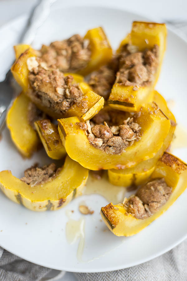 Delicata Squash Crumble Slices: You'll love this sweet and cinnamony crumble stuffed inside of a delicata squash! It's the perfect healthy, gluten free, and vegan side for your holiday festivities! || fooduzzi.com recipe