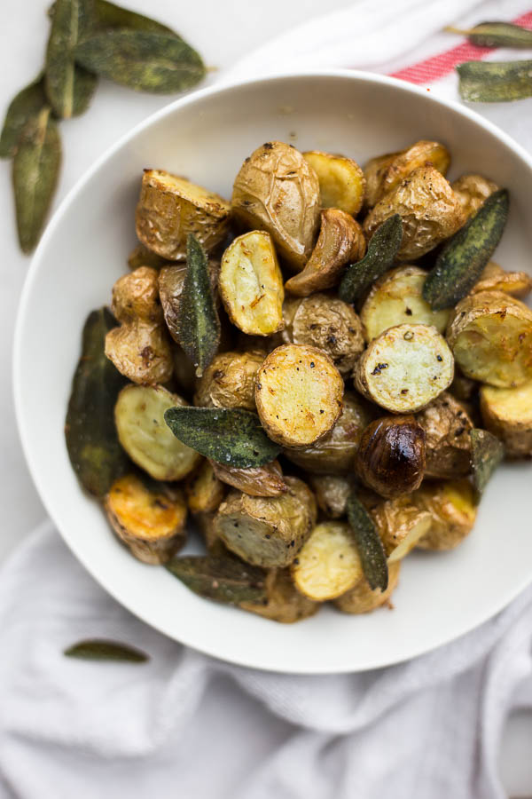 Lemon Roasted Potatoes with Fried Sage: ultra crispy and tender, these potatoes make for a beautiful gluten free and vegan side dish. Try it as a healthier Thanksgiving side! || fooduzzi.com recipes