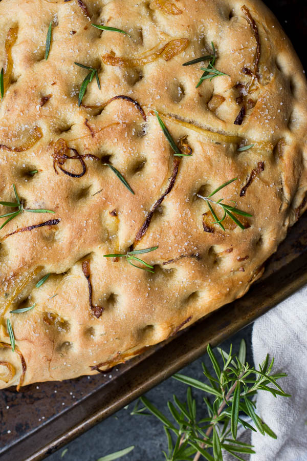 Caramelized Onion Rosemary Focaccia Bread: Tender, rich homemade bread made slightly sweet and herby. Naturally vegan, and the perfect accompaniment to an Italian feast! An easy yeast dough recipe! || fooduzzi.com recipes
