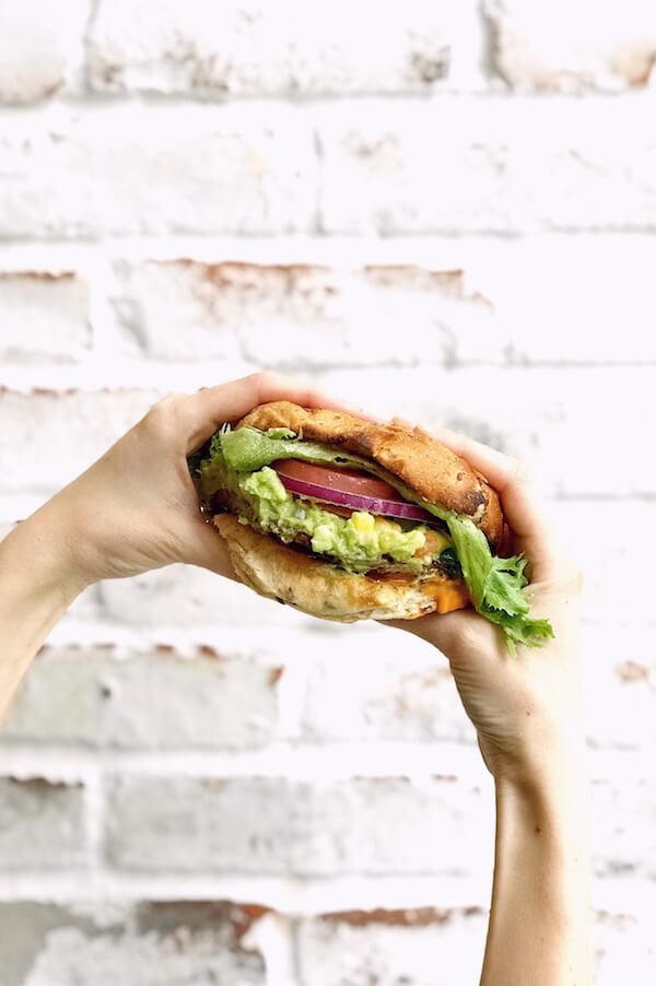 veggie burger against a white brick wall