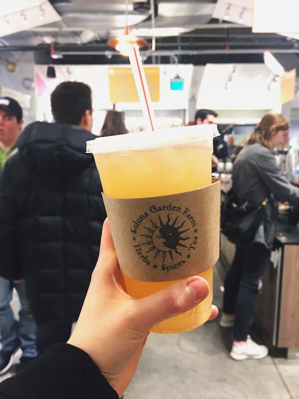 a cup of kombucha in someone's hand