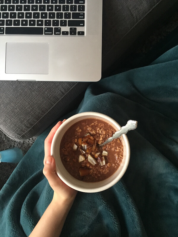 a bowl of chocolate oatmeal with dates and a spoon