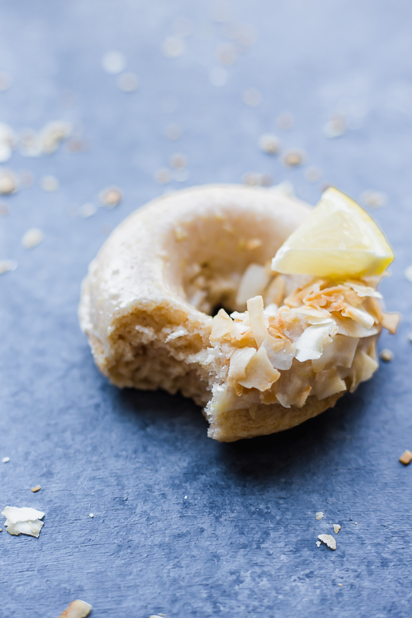 lemon coconut donut with a bite taken out of it