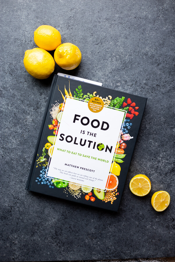 the "Food is the Solution" cookbook on a dark background