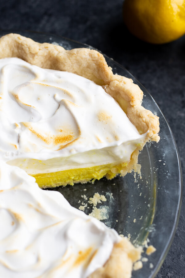 A cut vegan lemon meringue pie in a pie dish
