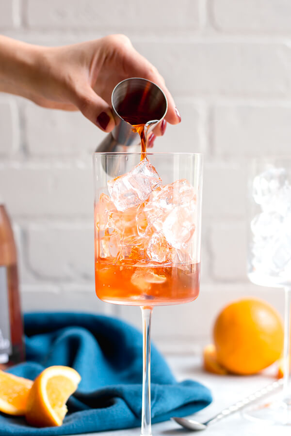 pouring aperol into a glass