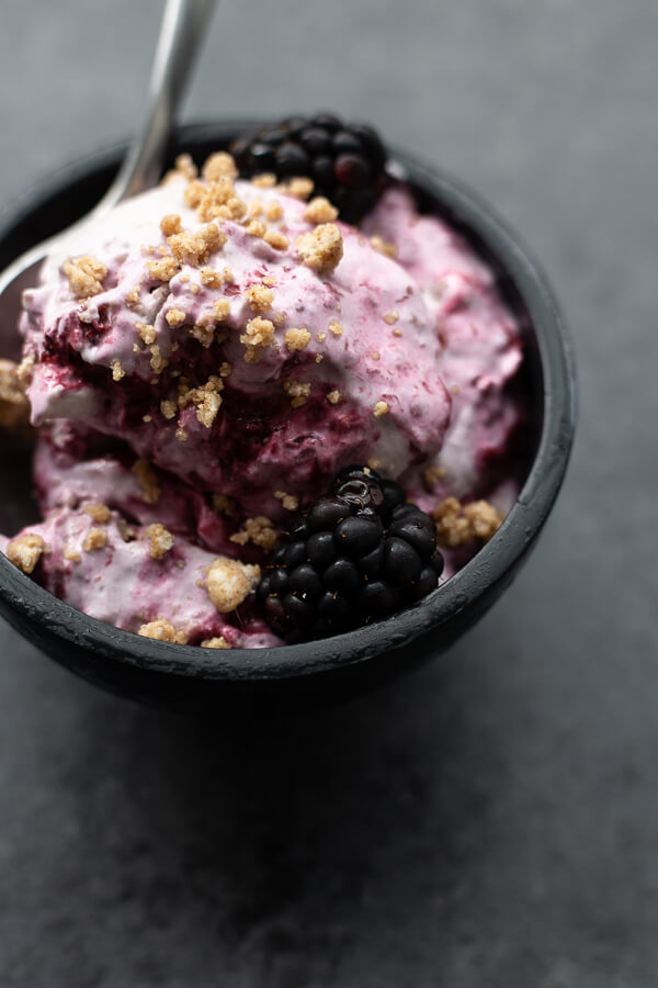 a bowl of vegan blackberry bourbon crumble ice cream with a spoon