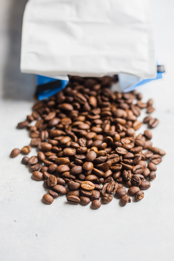 an open bag of coffee with beans spilling out