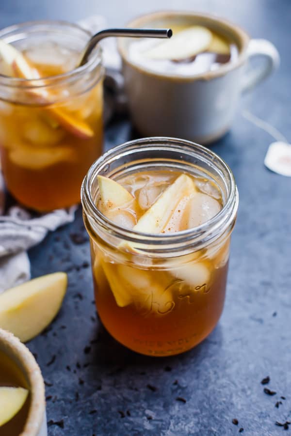 cup of apple cider tea with ice and apple slices