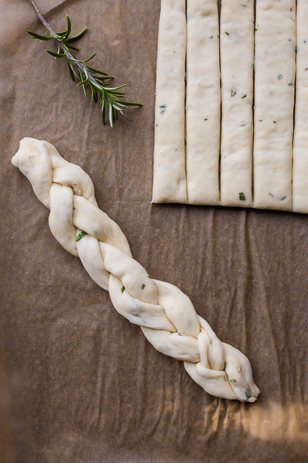 a raw braided rosemary parmesan breadstick with rosemary