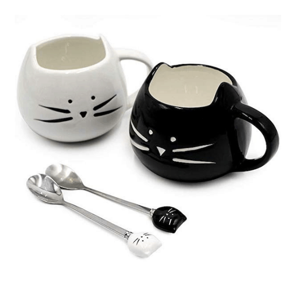 a white cat mug and a black cat mug with spoons