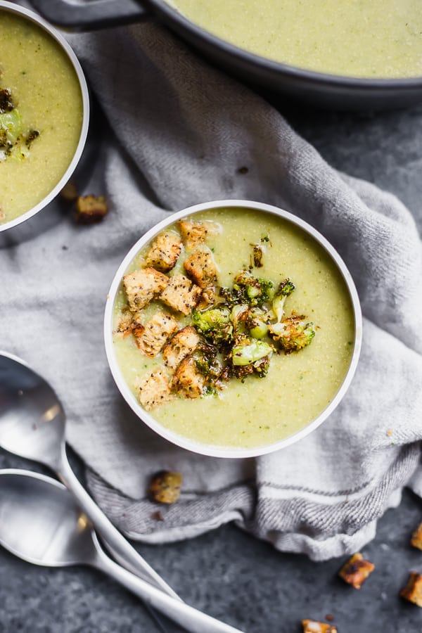 a bowl of broccoli soup with croutons and broccoli on top