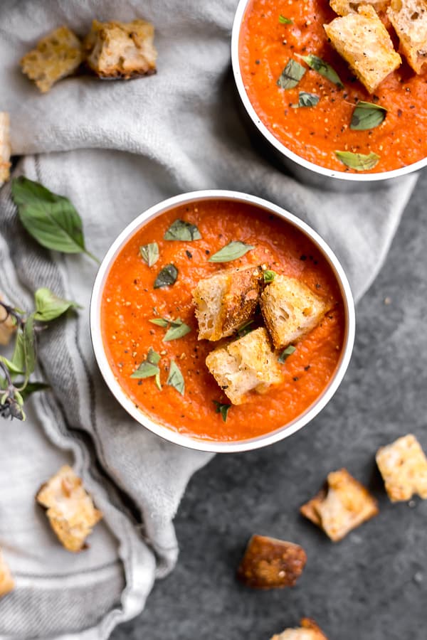 two bowls of vegan san marzano tomato soup with croutons