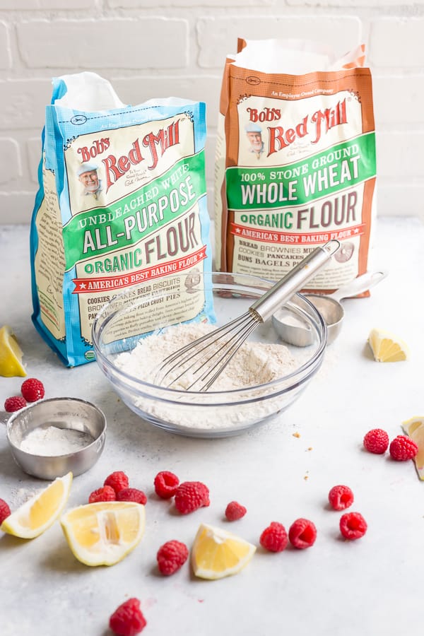 two bags of Bob's Red Mill Organic Flour with a bowl and a whisk