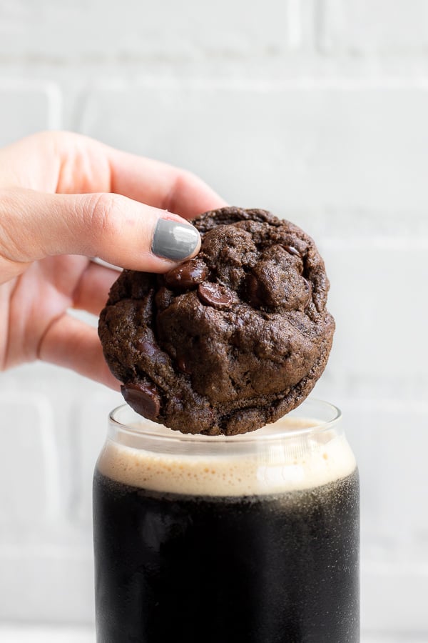 Hand dipping a Chocolate Beer Cookie into a cup of stout