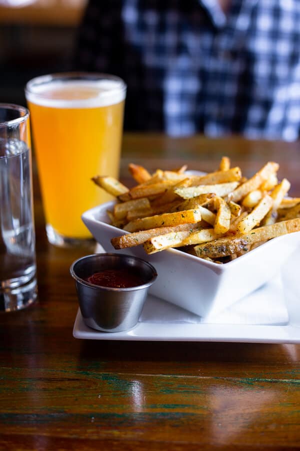 french fries, beer, and ketchup on a table at Urban Tap in Pittsburgh, PA