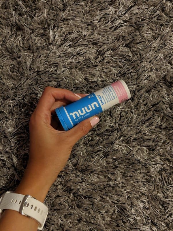 a hand holding a tube of nuun sport tablets