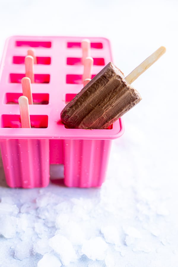 a chocolate popsicle sticking out of a popsicle mold