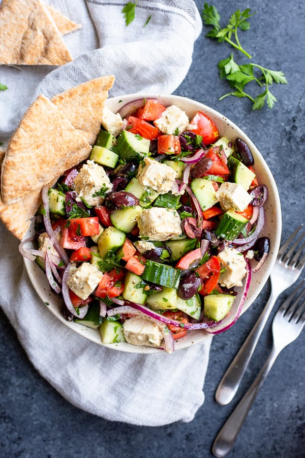 Vegan Greek Salad with Tofu Feta in a bowl with pita