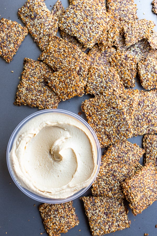 Sesame Flax Crackers from the Food52 Vegan cookbook with hummus on a baking sheet