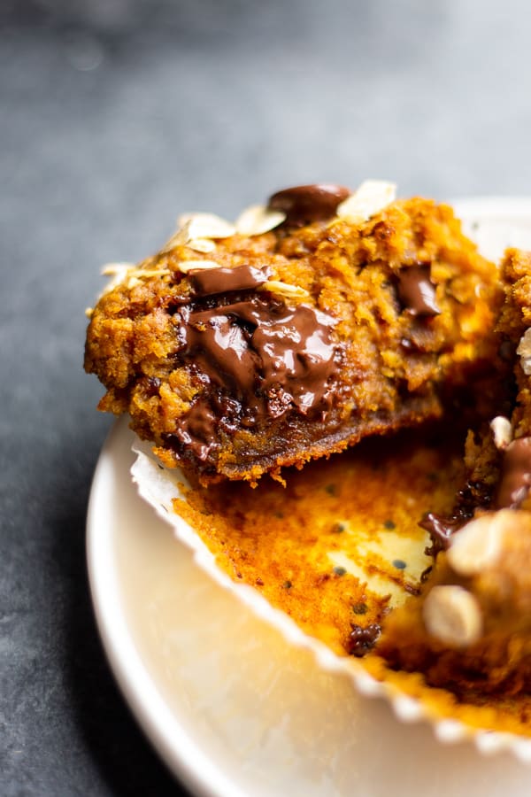 An unwrapped Vegan Blender Pumpkin Muffin with melty chocolate inside