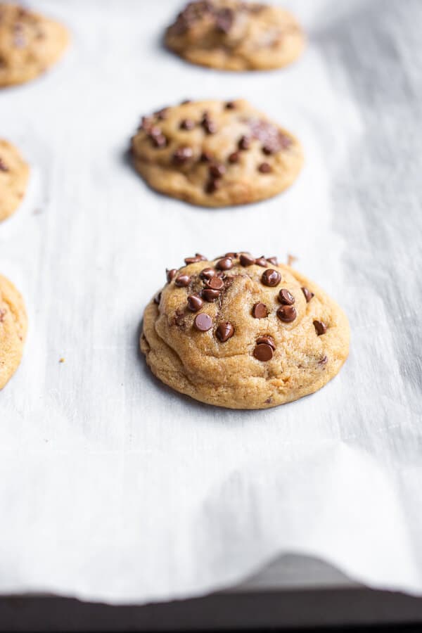 A parchment-lined baking sheet with Chewy Vegan Peanut Butter Cup Cookies cooling on top