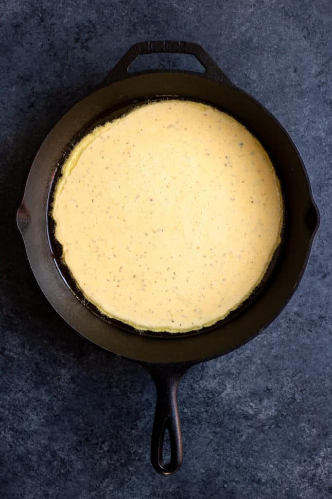 uncooked socca flatbread batter in a cast iron skillet