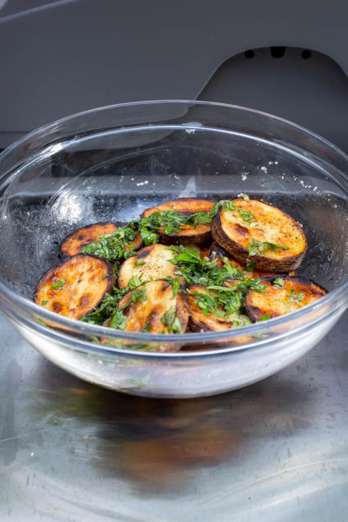 grilled potatoes in a bowl drizzled with herb oil