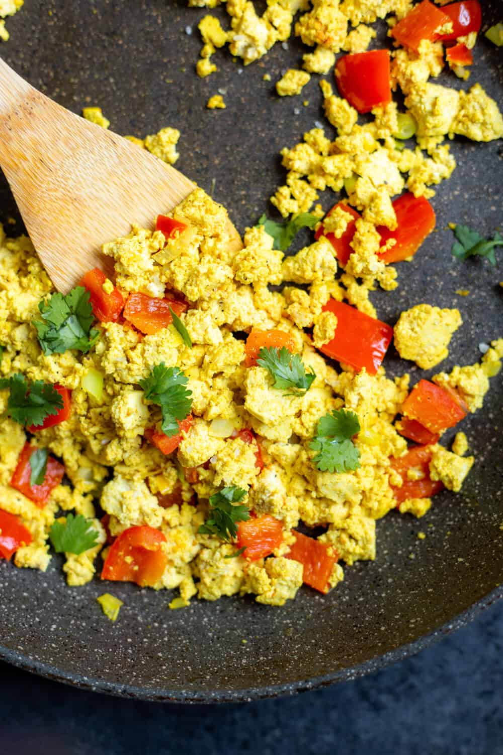 tofu scramble with peppers, onion, and cilantro in a pan