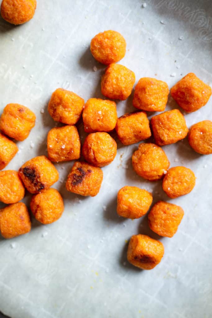 sweet potato tater tots on a parchment-lined baking sheet
