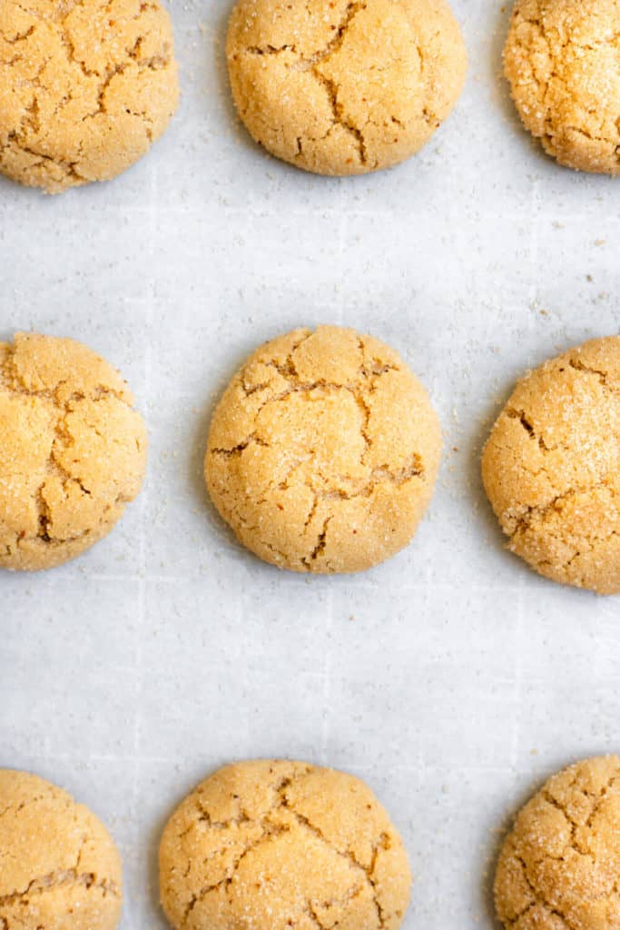 baked vegan maple pumpkin spice snickerdoodles on a parchment-lined baking sheet