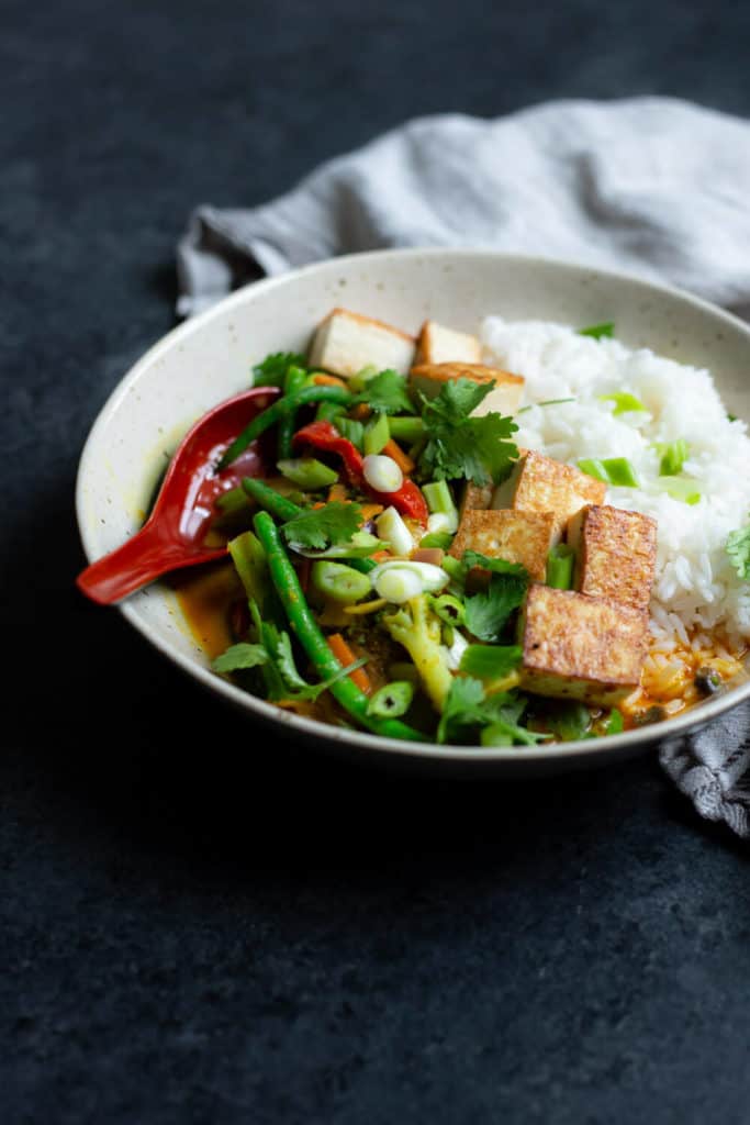 vegan pineapple curry in a bowl with crispy tofu and rice