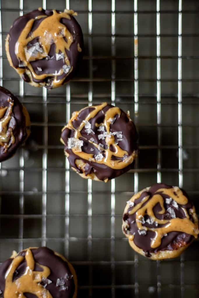 vegan chocolate peanut butter cookie dough bites on a cooling rack covered in flaky salt