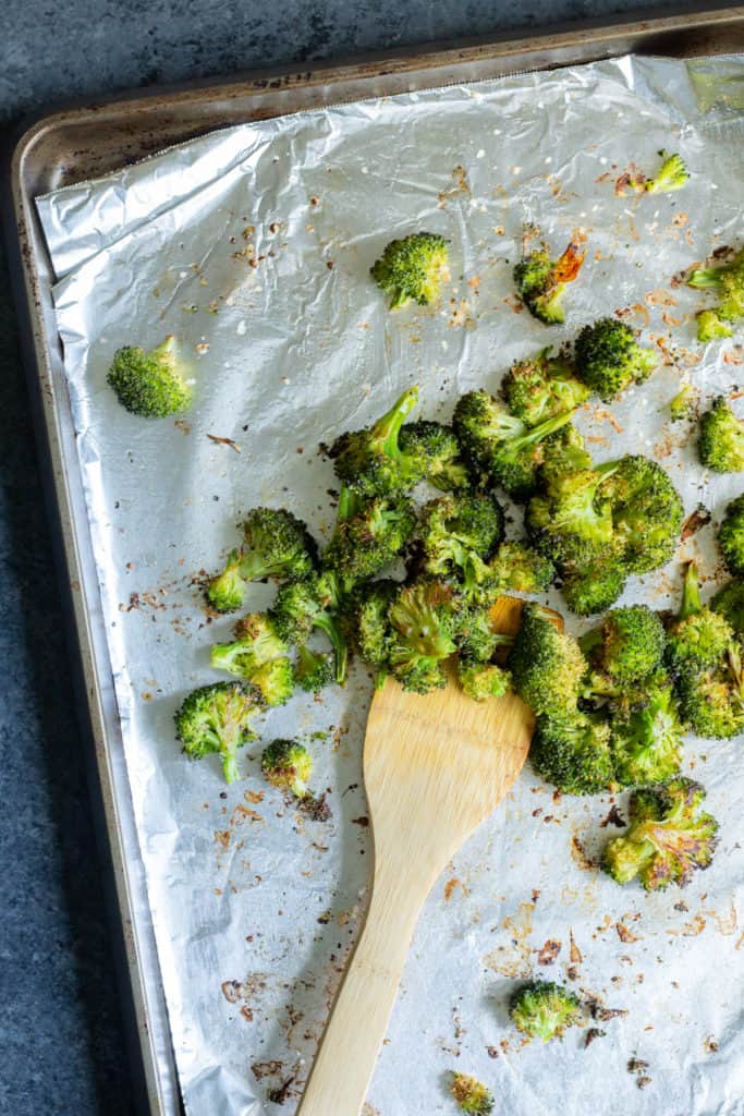 a pan of roasted broccoli on aluminum foil
