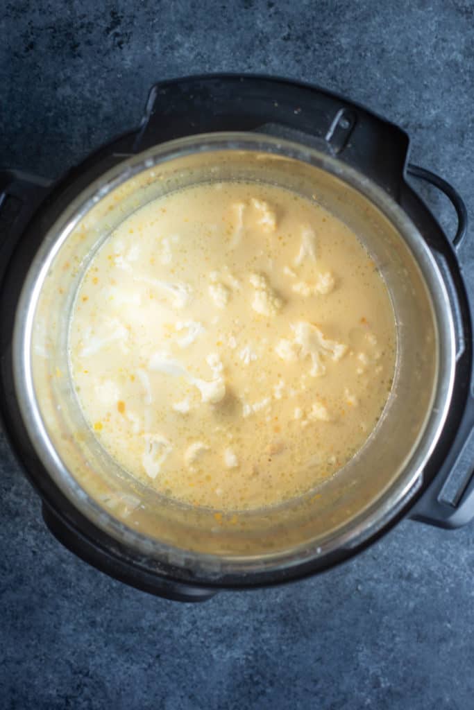 an Instant Pot with the ingredients for a creamy vegan cheese sauce in it