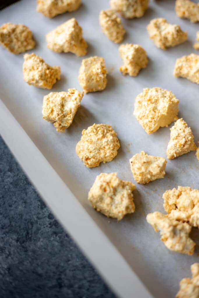 unbaked tofu nuggets on a parchment-lined baking sheet