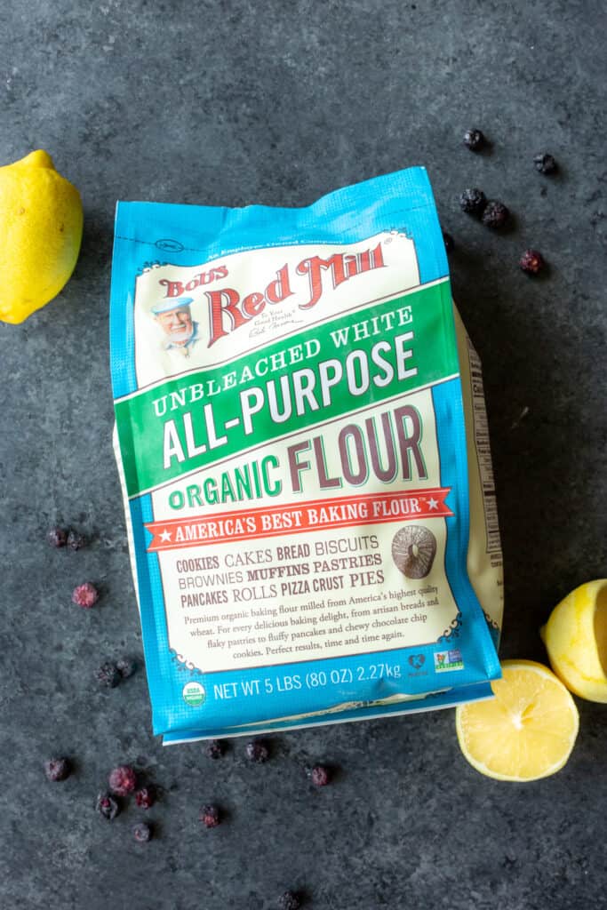 a bag of Bob's Red Mill Organic All-Purpose Flour with lemons and blueberries around the bag