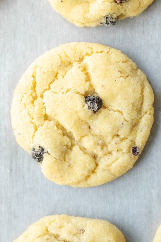 a baked vegan lemon blueberry sugar cookie on a parchment-lined baking sheet