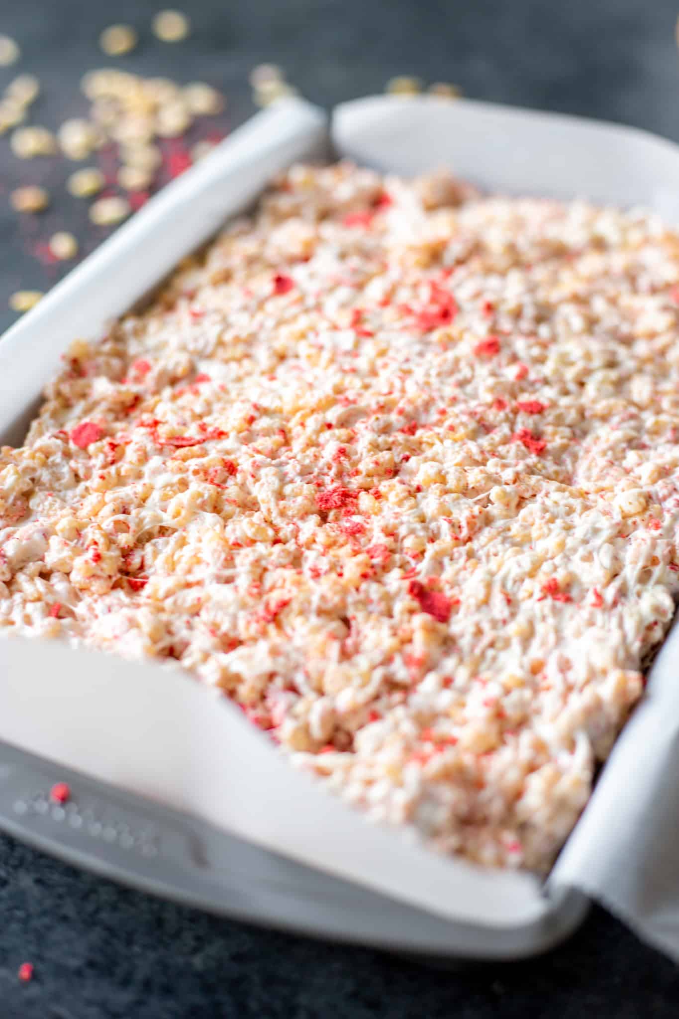 strawberries and cream crispy rice treats in a pan uncut