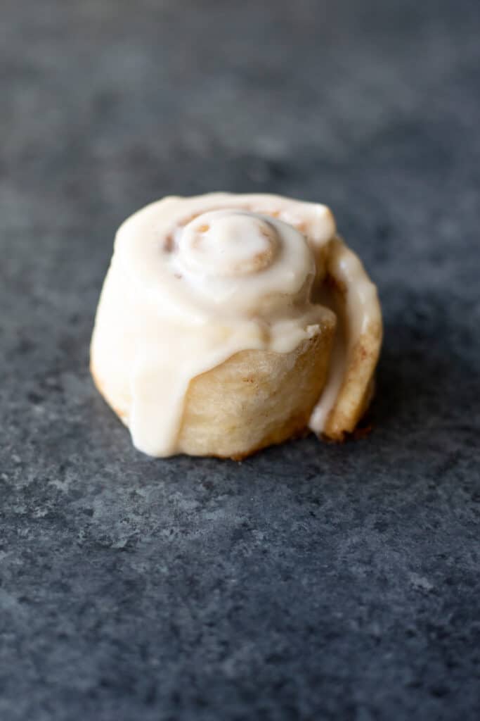 a side view of an iced vegan single serving cinnamon roll