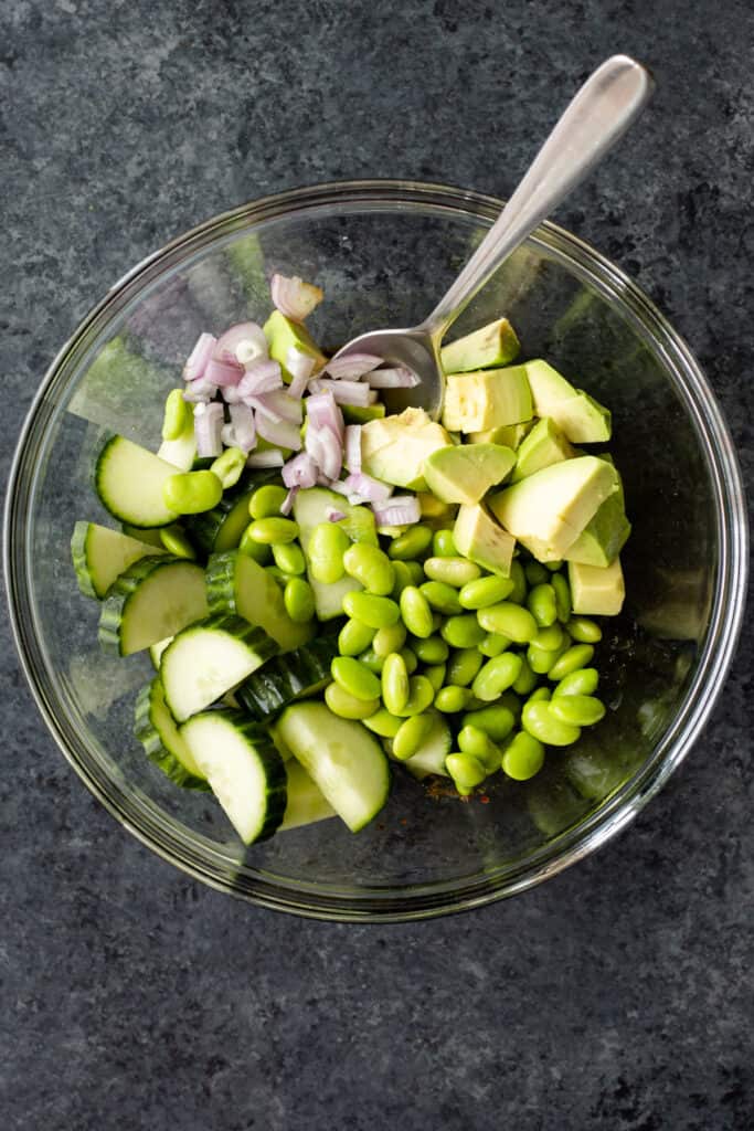 the cucumber, edamame, avocado salad ingredients in a glass bowl