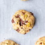 a few date pistachio chocolate chunk cookies on a parchment-lined baking sheet