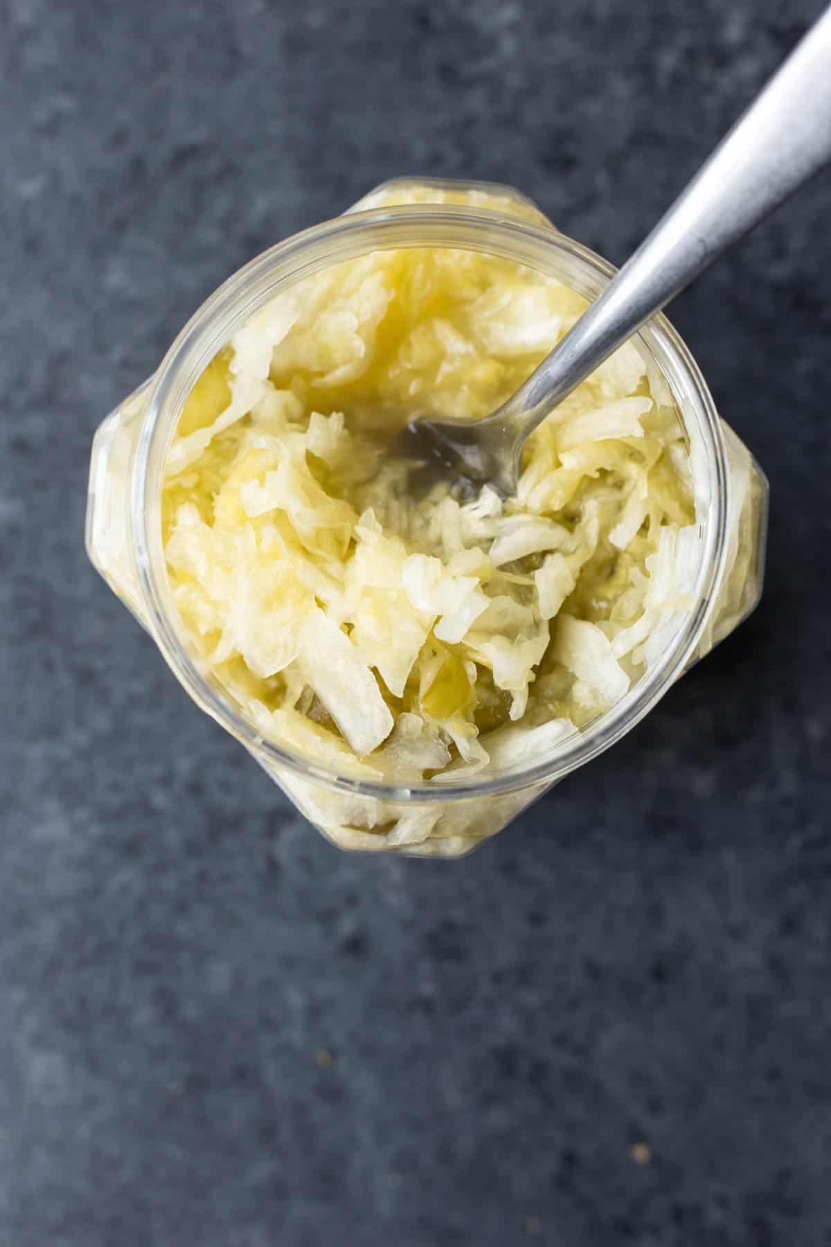 a jar of sauerkraut with a spoon in it