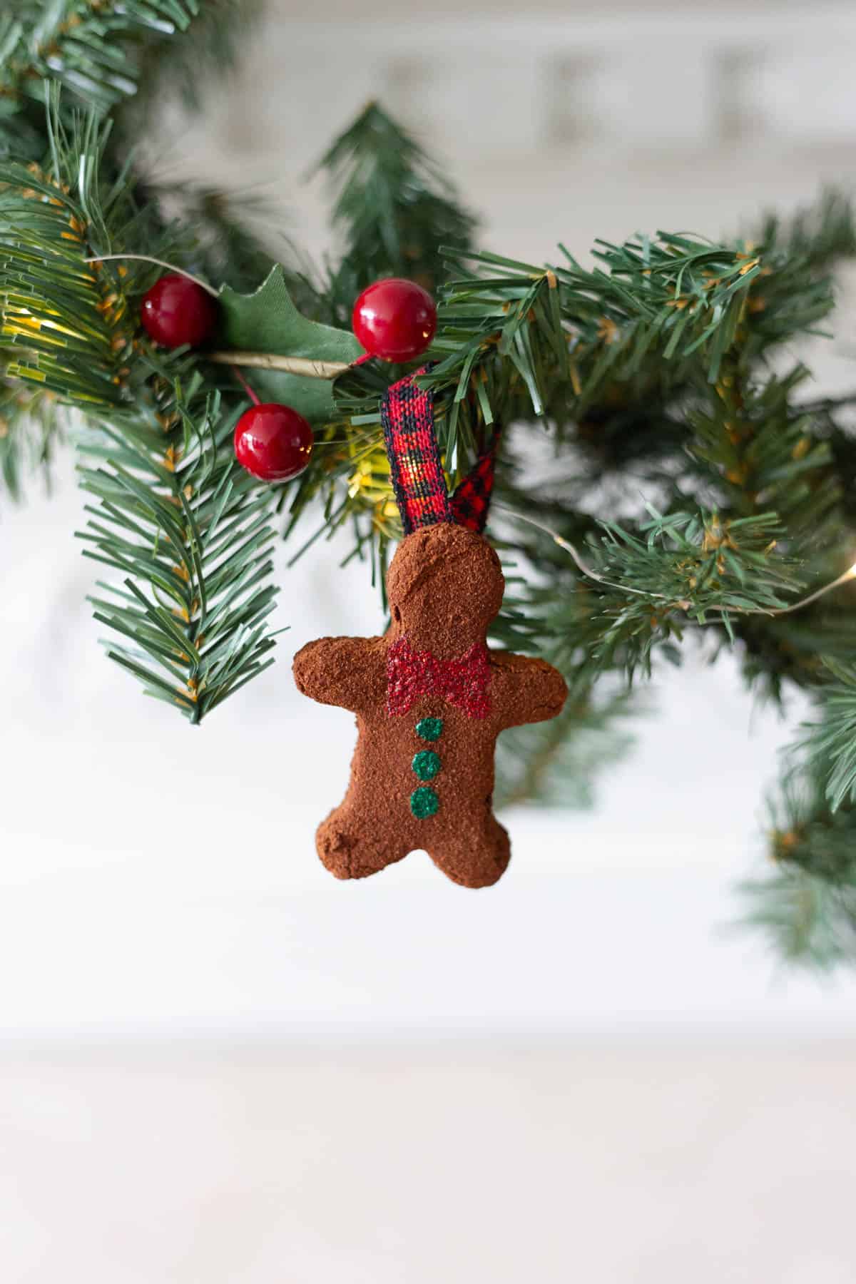 A gingerbread man Cinnamon ornament hanging on a garland