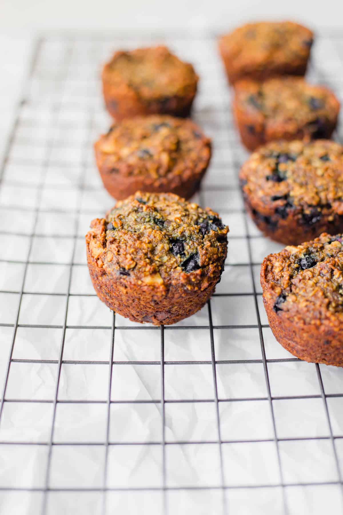 vegan blueberry walnut oatmeal muffins on a cooling rack