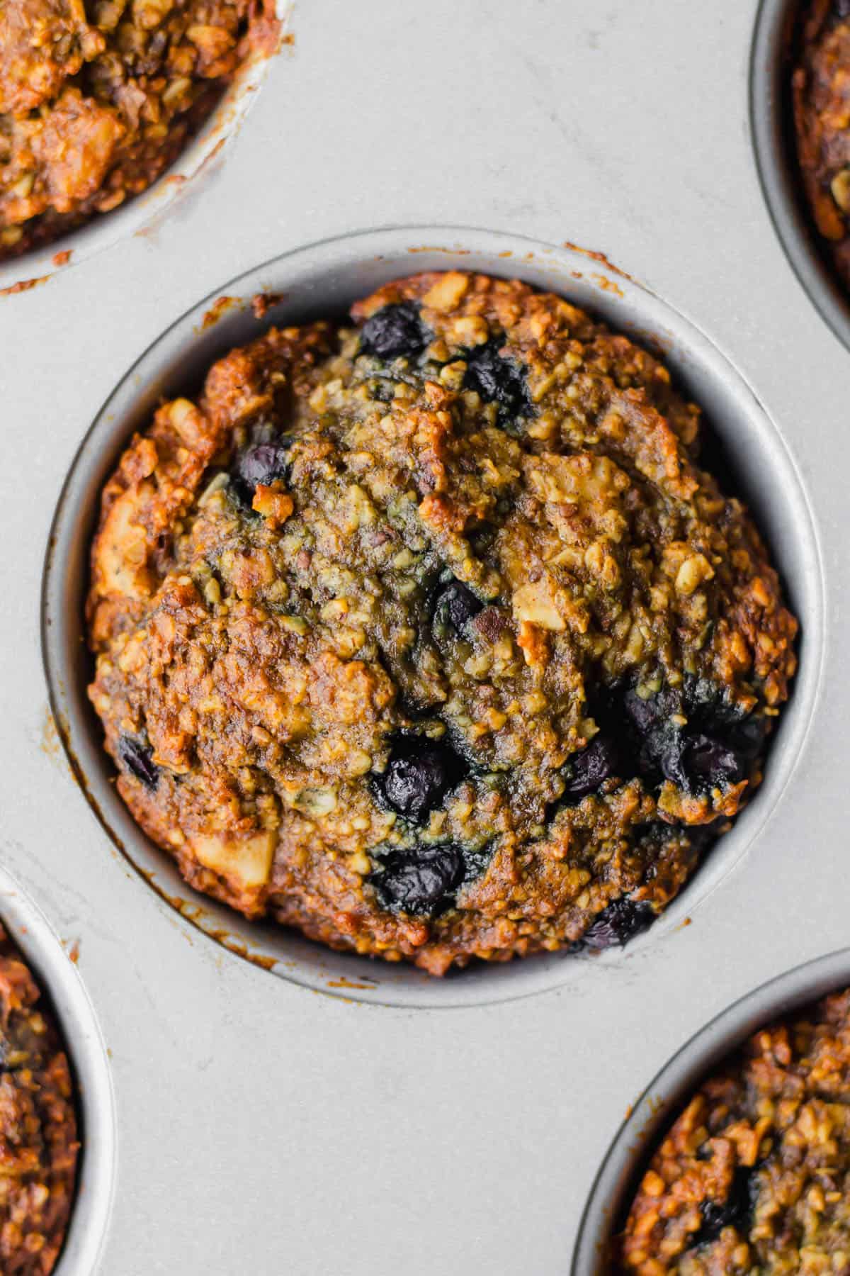 a Vegan Blueberry Walnut Oatmeal Muffin in a muffin pan